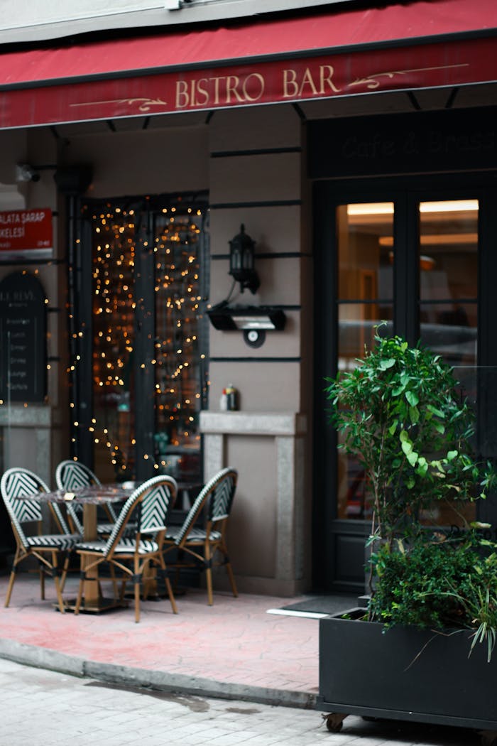 Cozy bistro bar entrance with seating and ambient lighting in an urban street setting.